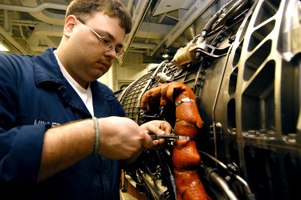US Navy 040129-N-6278K-003 Aviation Machinist's Mate Airman Brandon Miller, from Harrisburg, Pa., works on a jet engine in the Aviation Intermediate Maintenance Department's (AIMD) jet shop aboard USS George Washington