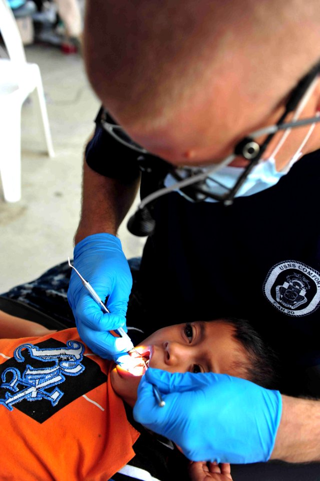 US Navy 110715-F-NJ219-256 Lt. Cmdr. Michael Rudmann, a dentist from Derwood, Md., cleans a patient's teeth during a Continuing Promise 2011 commun