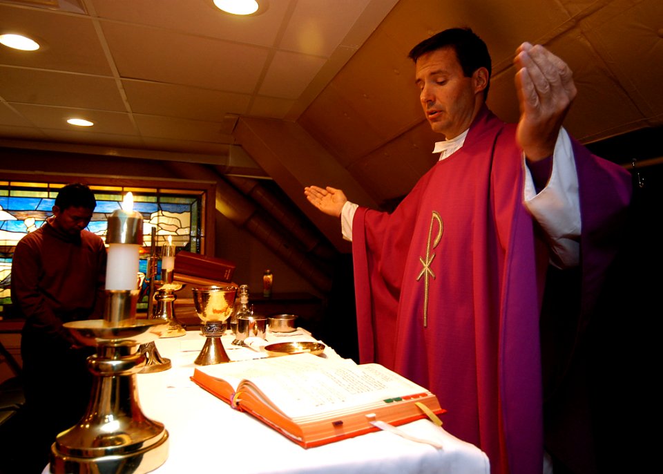 US Navy 040312-N-6278K-038 Navy Chaplain, Lt. Joe Coffey, of Philadelphia, Pa., reads a prayer during a church service in the ship's chapel aboard USS George Washington (CVN 73)