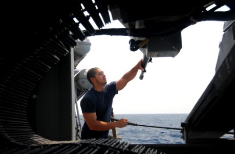 US Navy 110730-N-XQ375-119 Gunner's Mate 3rd Class Augustin Villatoro cleans an MK 38 25 mm machine gun aboard USS Mitscher (DDG 57)