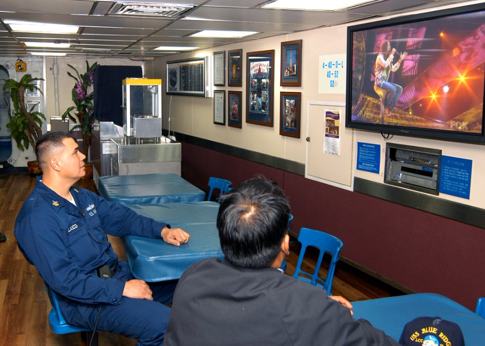 US Navy 040324-N-9860Y-045 Machinist's Mate 1st Class William Velasco, from Batanes, Philippines and a shipmate watch Velasco's daughter, Camile Velasco, 18, of Maui, Hawaii, perform her rendition of the classic song Desperado