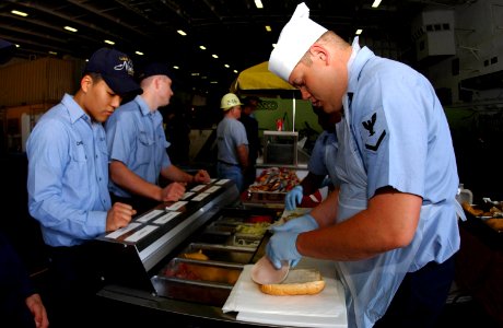 US Navy 040310-N-2143T-002 Culinary Specialist 3rd Class Adam Elliot, of Mount Virden, Ill., prepares sandwiches for sailors aboard USS Nimitz (CVN 68) photo