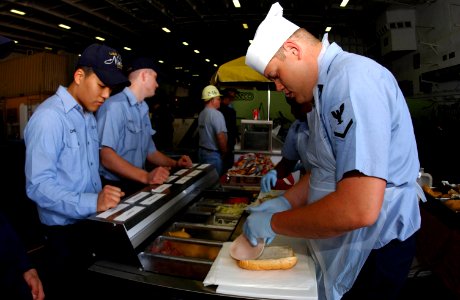 US Navy 040310-N-2143T-002 Culinary Specialist 3rd Class Adam Elliot, of Mount Virden, Ill., prepares sandwiches for sailors aboard USS Nimitz (CVN 68)