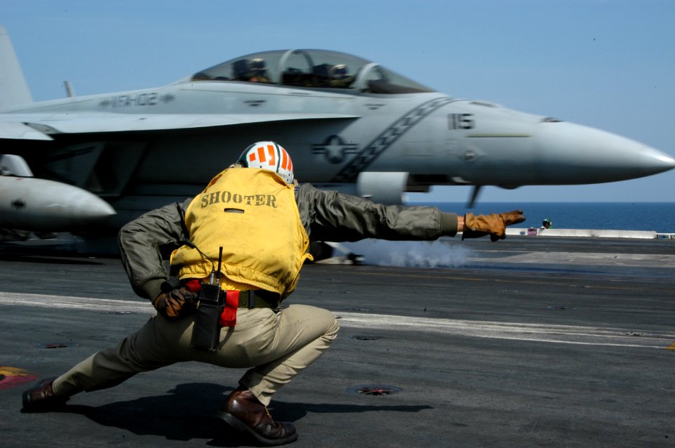 US Navy 040321-N-5821P-004 An F-A-18F Super Hornet assigned to the Diamondbacks of Strike Fighter Squadron One Zero Two (VFA-102) launches past Lt. Cmdr. Mark W. Kekeisen, of St. Louis, Mo