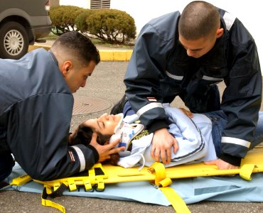 US Navy 040323-N-0000W-013 Hospital Corpsman Fernando Prieto and Hospital Corpsman Raulito Galgana demonstrate life saving techniques in the parking lot outside the Emergency Room of U.S. Naval Hospital Yokosuka, Japan photo