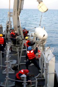 US Navy 040218-N-0000W-001 Deck personnel aboard the mine countermeasure ship USS Guardian (MCM 5) recover gear after completing a mine sweep