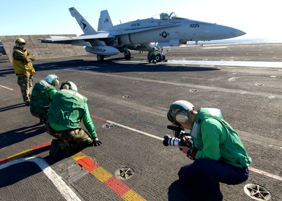 US Navy 040219-N-4374S-009 Photographer's Mate 3rd Class Christian Weibull captures video images of the flight deck personnel during operations