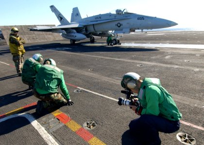 US Navy 040219-N-4374S-009 Photographer's Mate 3rd Class Christian Weibull captures video images of the flight deck personnel during operations