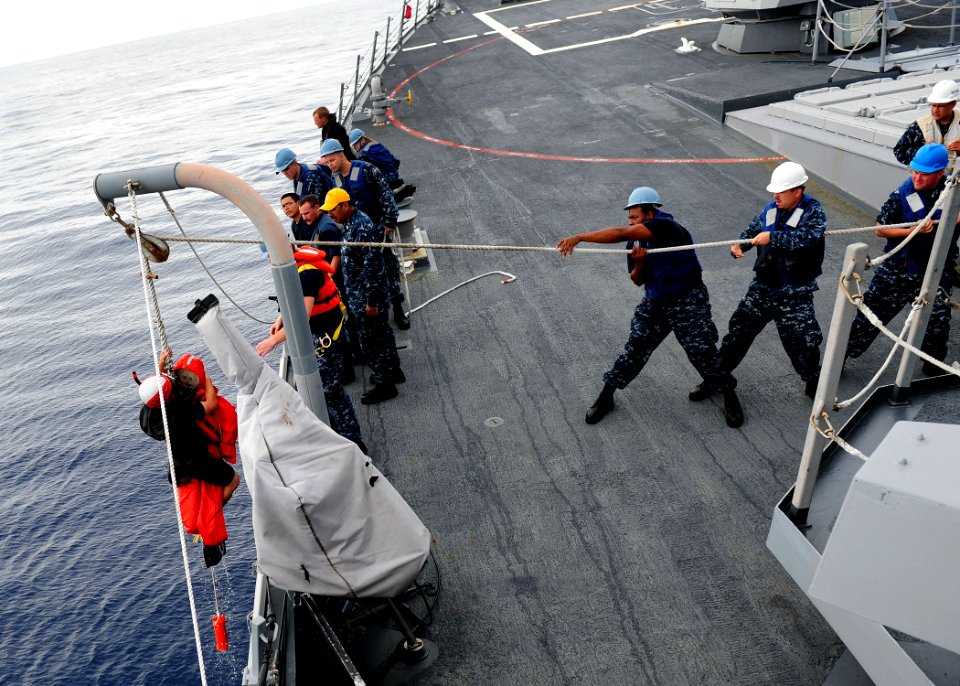 US Navy 111012-N-ED900-051 Search and rescue swimmer Seaman Skylar Shirley is lifted from the water after recovering Oscar, a man overboard rescue