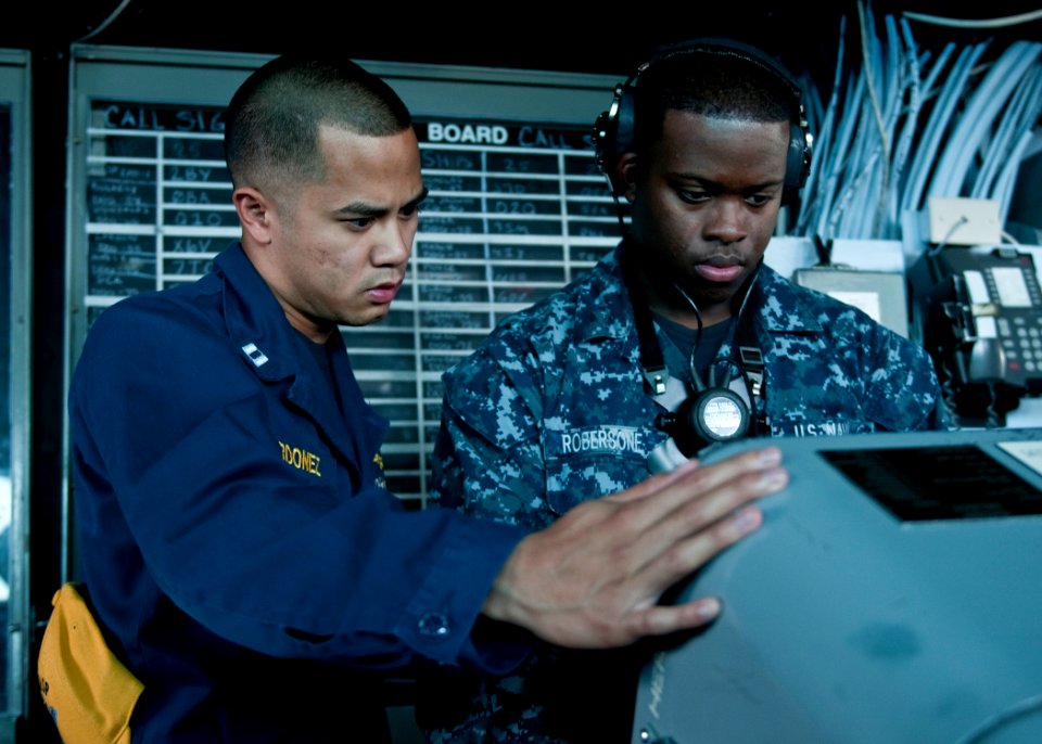 US Navy 110825-N-PM781-002 Operations Specialist Seaman Rickey Robersone, right, receives direction from officer of the deck Lt. Michael Ordonez ab