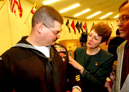 US Navy 040223-N-5576W-006 Parents of Hospital Corpsman 2nd Class Joseph Dementer, admire the Bronze Star their son received for courage under fire