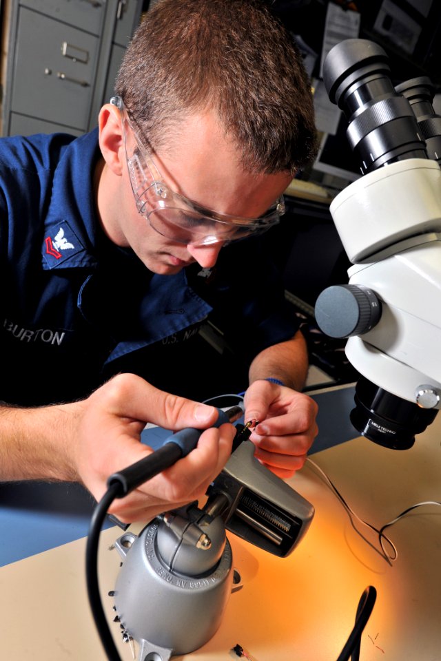 US Navy 110907-N-YZ751-036 Electronics Technician 2nd Class Aaron E. Burton prepares to solder a damaged wire aboard USS Truxtun (DDG 103)