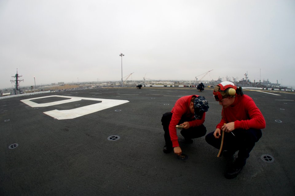 US Navy 110830-N-ZC343-446 Sailors perform maintenance on flight deck sprinkler heads aboard USS Bonhomme Richard (LHD 6)