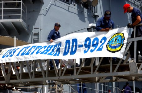 US Navy 040525-N-3019M-003 Sailors assigned to the Spruance Class destroyer USS Fletcher (DD 992) attach the ship's banner to the brow after returning to Pearl Harbor for a two-day port visit