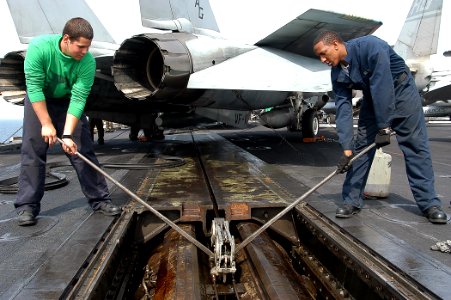 US Navy 040327-N-3986D-012 Airman Gregg Prince, of Virginia Beach, Va., and Airman Phillip Lydian, of Bardstown, Ky., perform maintenance on a steam-powered catapult aboard USS George Washington (CVN 73)