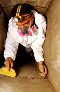 US Navy 040420-N-2143T-001 Aviation Boatswain's Mate 3rd Class Ricardo Manjarrez, of Nogales, Ariz., scrubs-out dust collected in vents