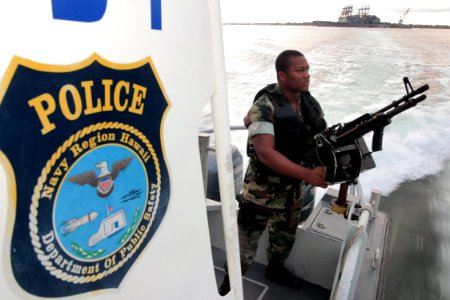 US Navy 040329-N-3228G-001 Master-at-Arms Seaman Ray Cowan, assigned to Naval Station Pearl Harbor Security, mans an M-60 machine gun aboard a 28-foot Sea Ark patrol boat
