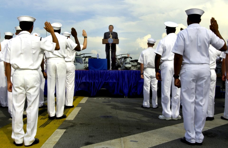 US Navy 040604-F-6655M-049 Sailors aboard the amphibious assault ship USS Essex (LHD 2) raise their right had while repeating the oath of enlistment, during a reenlisted ceremony conducted on the ship's flight deck by the U.S