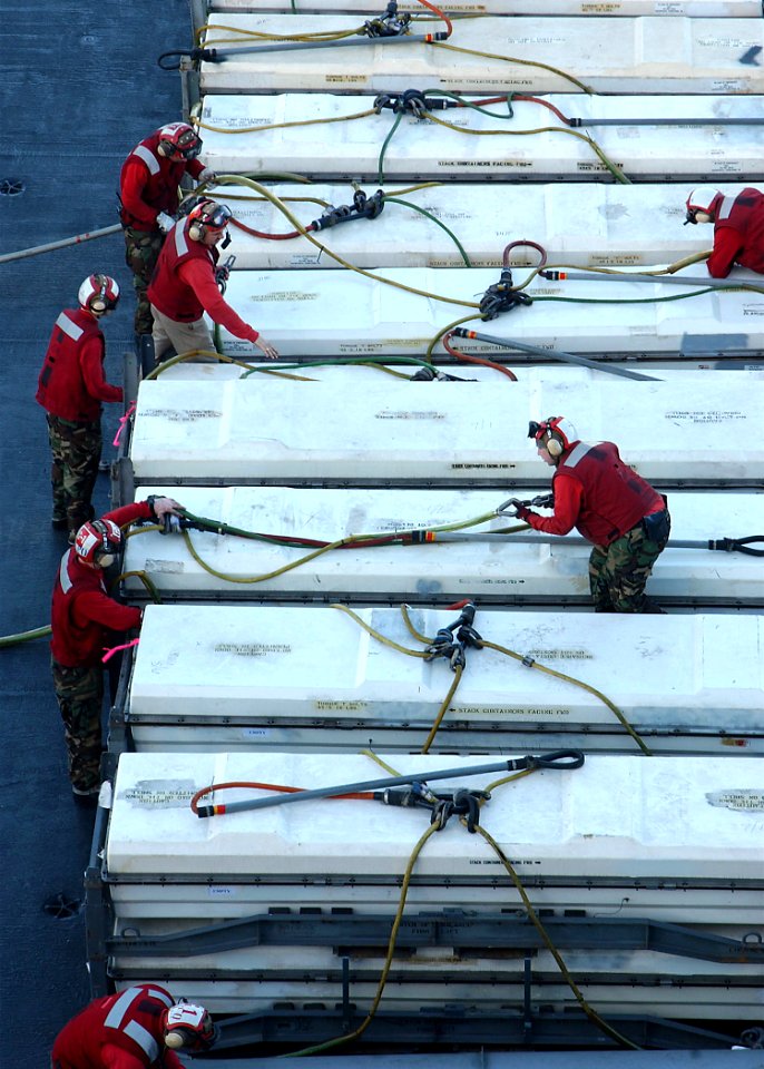 US Navy 040604-N-7871M-079 Weapons Department crew members receive ordnance from the Military Sealift Command ship USNS Supply (T-AOE 6) on the flight deck aboard USS George Washington (CVN 73