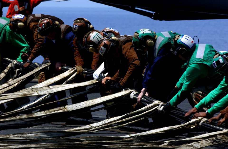 US Navy 040413-N-5821P-004 Sailors work together to raise the emergency barricade during a flight deck drill aboard USS Kitty Hawk (CV 63)