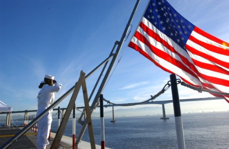 US Navy 040611-N-9319H-054 USS Ronald Reagan (CVN 76) Sailors salute the American flag during the memorial service for President Ronald Reagan on the flight deck aboard his namesake aircraft carrier