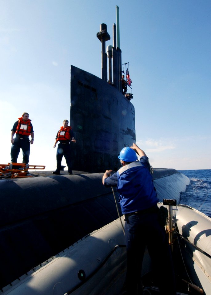 US Navy 040313-N-4374S-006 A Sailor assigned to the Arleigh Burke-class destroyer USS Roosevelt (DDG 80) tosses a forward line to Sailors aboard the fast-attack submarine USS Toledo (SSN 769)