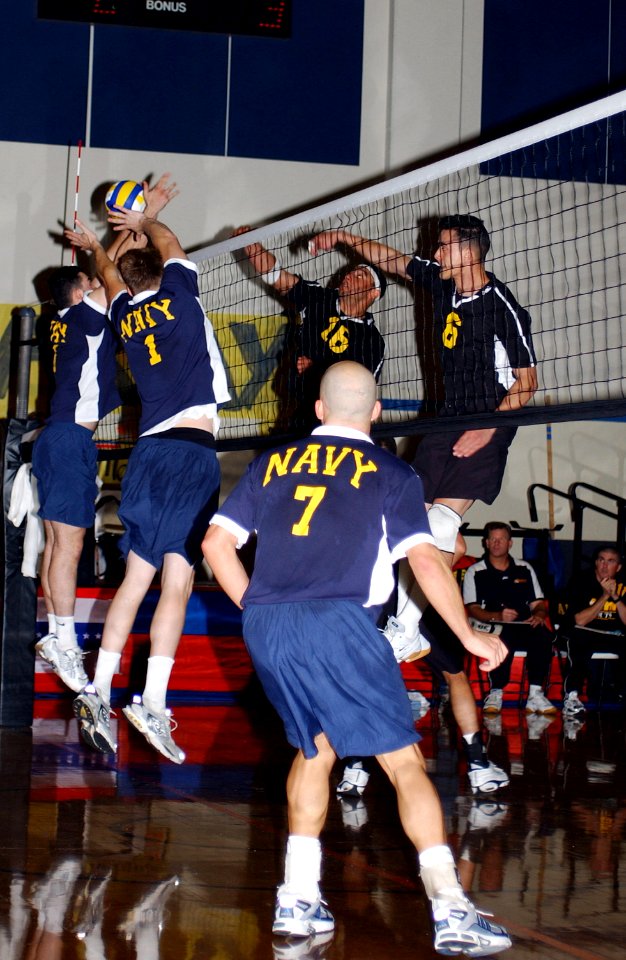 US Navy 040524-F-8156G-001 U.S. Navy Midshipman Sean Burke, far left, and John Mills of Andrews Air Force Base, Md., block Army hitter Dylan Mack, Ft. Lewis, Wash., at the 2004 Armed Forces Volleyball Tournament