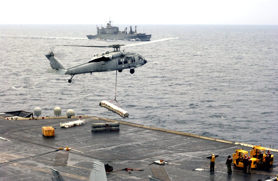 US Navy 040322-F-0193C-004 A MH-60S Knighthawk helicopter assigned to the Providers of Helicopter Combat Support Squadron Five (HC-5) move supplies around during a replenishment at sea (RAS) for USS Kitty Hawk (CV 63)