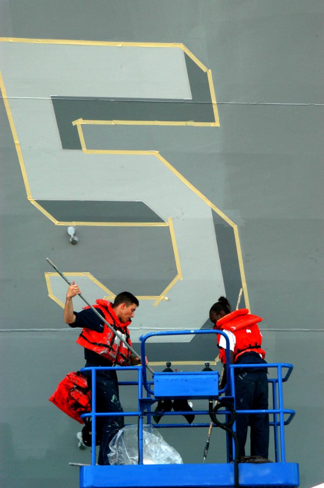US Navy 040622-N-4104L-020 Seaman Brian Mattern, left, and Seaman Dominique Whitlock repaint the hull number of the guided missile destroyer USS McCampbell (DDG 85)