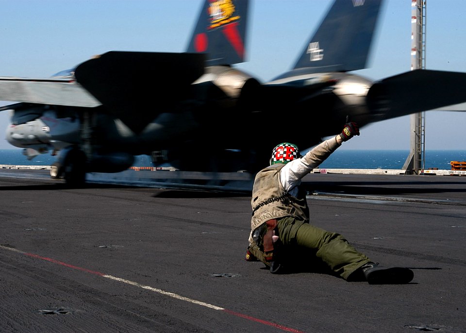 US Navy 040322-N-3986D-041 Aviation Structural Mechanic 3rd Class Francis Heller, of Virginia Beach, Va., signals that its safe to launch a F-14B Tomcat assigned to the Red Rippers of Fighter Squadron One One (VF-11) aboard USS