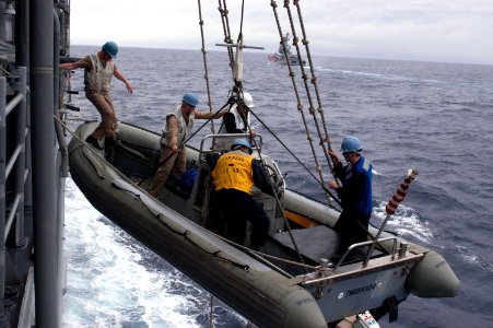 US Navy 040702-N-1194D-001 Sailors assigned to the guided missile cruiser USS Cowpens (CG 63) climb into a Rigid Hull Inflatable Boat (RHIB)