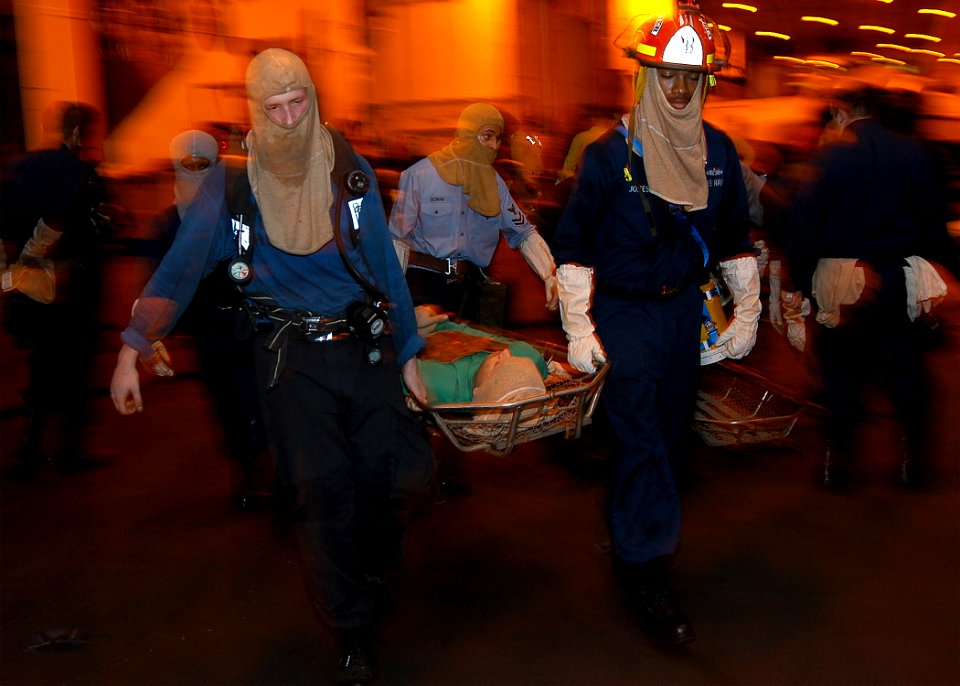 US Navy 040607-N-6433N-104 Repair locker stretcher bearers carry simulated injured personnel to a battle dressing station during a general quarters drill in the hangar bay aboard USS George Washington (CVN 73)