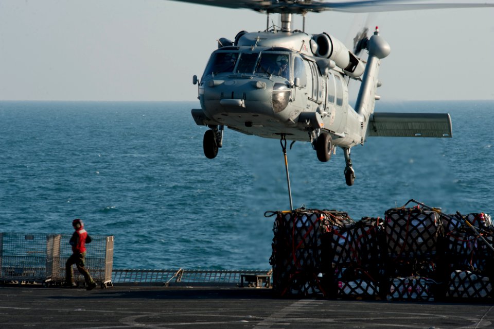 US Navy 111206-N-OY799-297 A helicopter picks up stores from the flight deck.