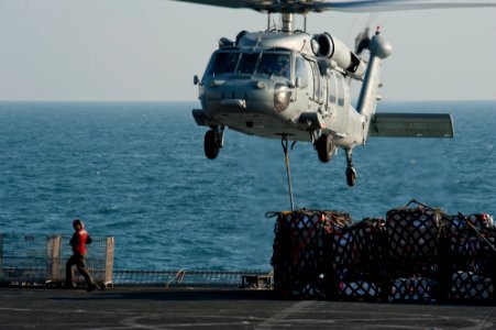 US Navy 111206-N-OY799-297 A helicopter picks up stores from the flight deck.