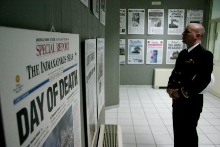 US Navy 040325-N-5821W-002 Lt. j.g. Chris Newell looks over copies of the front pages of newspapers featuring the events occurring on Sept. 11, 2001