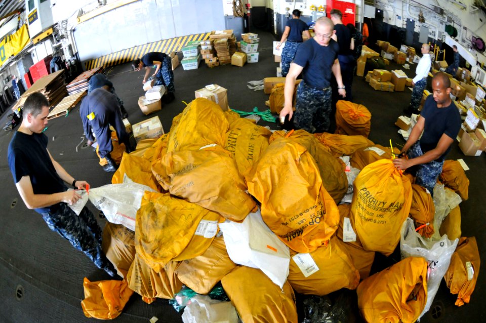 US Navy 111126-N-KM175-023 Sailors aboard the forward-deployed amphibious assault ship USS Essex (LHD 2) sort mail received from the Military Seal
