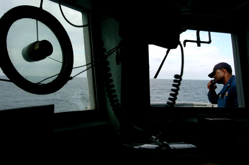 US Navy 040624-N-2653P-040 Chief Signalman Oliver Andrews, Afloat Training Group (ATG) communicates with fellow evaluators aboard the mine countermeasure ship USS Scout (MCM 8)