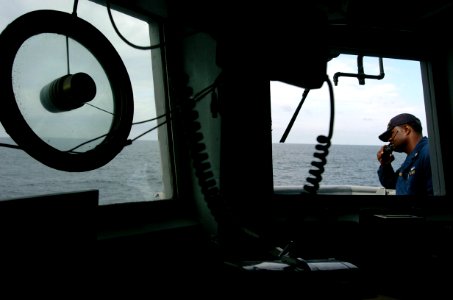 US Navy 040624-N-2653P-040 Chief Signalman Oliver Andrews, Afloat Training Group (ATG) communicates with fellow evaluators aboard the mine countermeasure ship USS Scout (MCM 8)