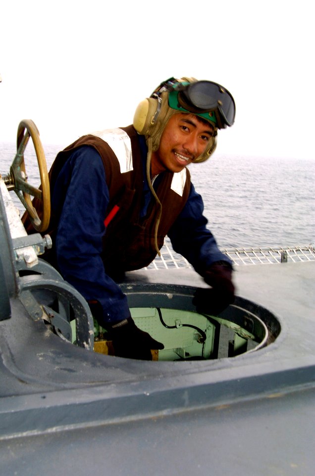 US Navy 040719-N-1464F-006 Aviation Machinist Mate 3rd Class John Barnachia opens the scuttle to the ship's Landing Signals Officer (LSO) shack aboard the guided missile cruiser USS Thomas S. Gates (CG 51) during UNITAS 45-04