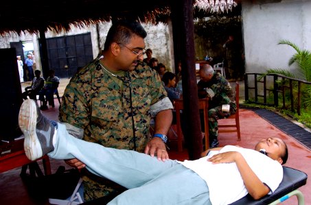 US Navy 040627-N-1464F-003 U.S. Naval Reserve Lt. Anthony Edwards checks the mobility of a local Peruvian woman during a medical evaluation
