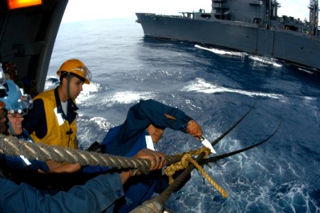 US Navy 040619-N-8704K-001 Boatswain Mate 3rd Class Joanna Saldana cuts the rope off a span wire aboard the aircraft carrier USS John F. Kennedy (CV 67) during an underway replenishment