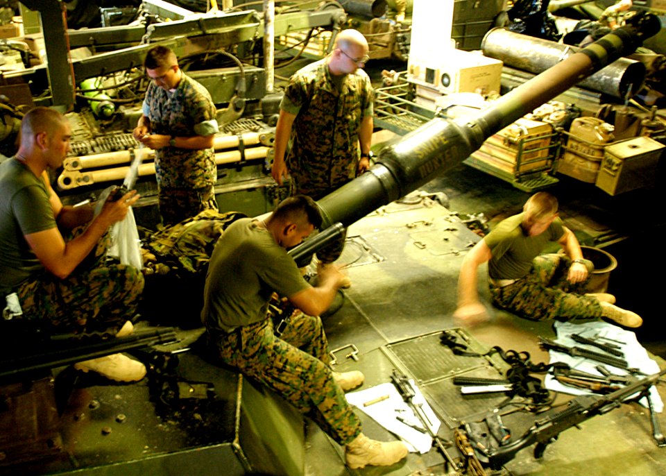 US Navy 040611-N-2972R-008 Marines perform maintenance on their weapons in the amphibious assault ship's upper vehicle storage area. USS Kearsarge (LHD 3)