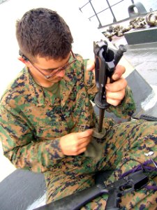 US Navy 040704-N-1464F-001 U.S. Marine Corps Lance Cpl. Jason Bauman cleans his M-16 A2 rifle while aboard the Peruvian tank landing ship B.A.P. Callao (DT-143). U.S. and Peruvian forces are preparing for the largest amphibious photo