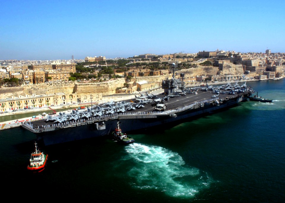 US Navy 040626-N-8704K-002 Tugboats assist the conventionally powered aircraft carrier USS John F. Kennedy (CV 67) while pulling pier-side in the port of Valletta, Malta