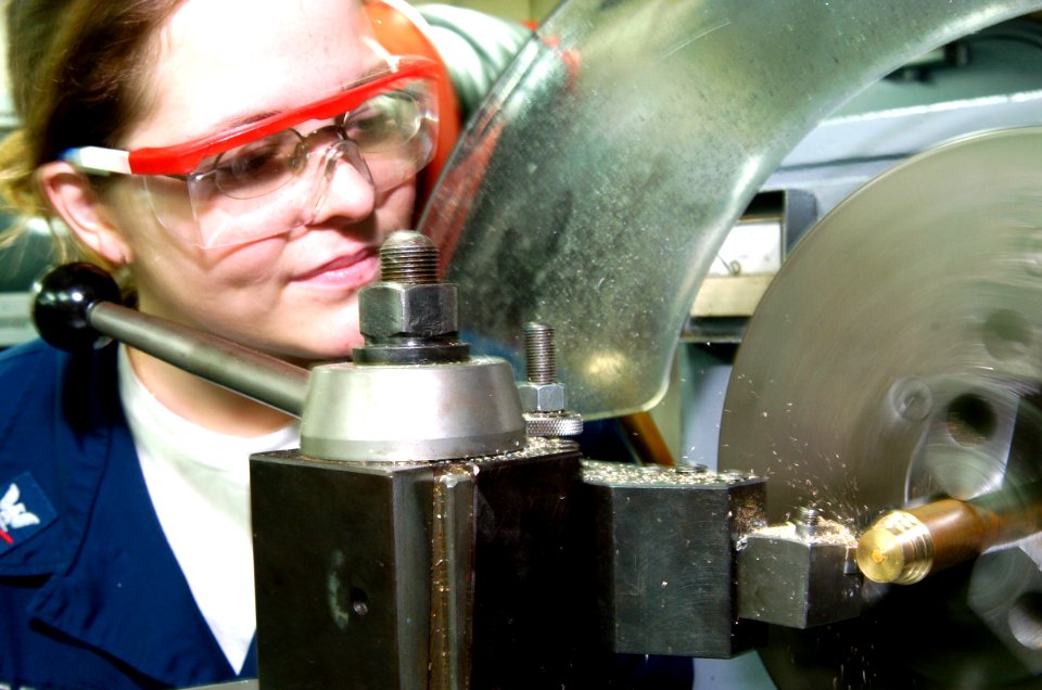 US Navy 040721-N-1464F-002 Machinery Repairman 3rd Class Marissa Cooper turns down a piece of brass using a Standard 20 inchlathe aboard the guided missile cruiser USS Thomas S. Gates (CG 51) during UNITAS 45-04