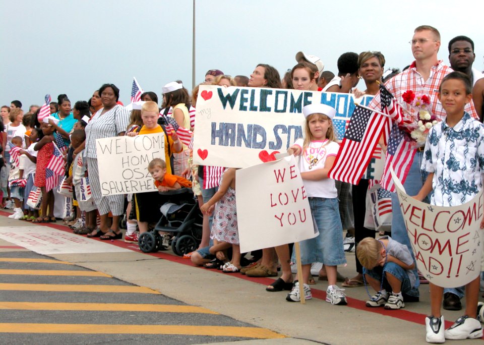 US Navy 040802-N-4397B-002 A huge crowd of family and friends anxiously await the mooring of the guided-missile cruiser USS Thomas S. Gates (CG 51), as the ship returns to its homeport at Naval Station Pascagoula, Pascagoula, M