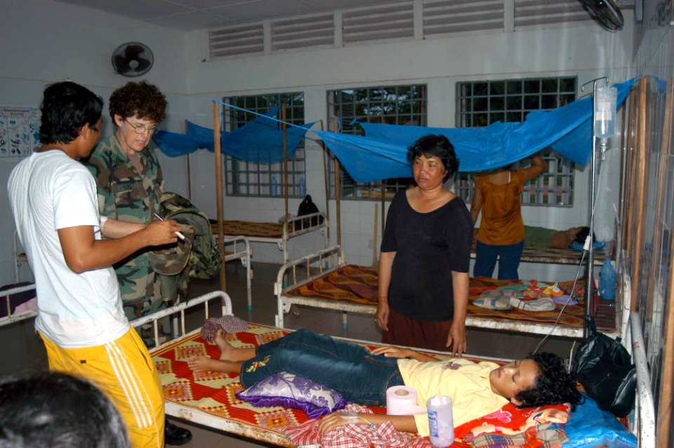 US Navy 040521-F-0518J-136 Kim Cham Roeun, left, translates questions presented by U.S. Navy Capt. Faye Pyles during rounds in a hospital compound