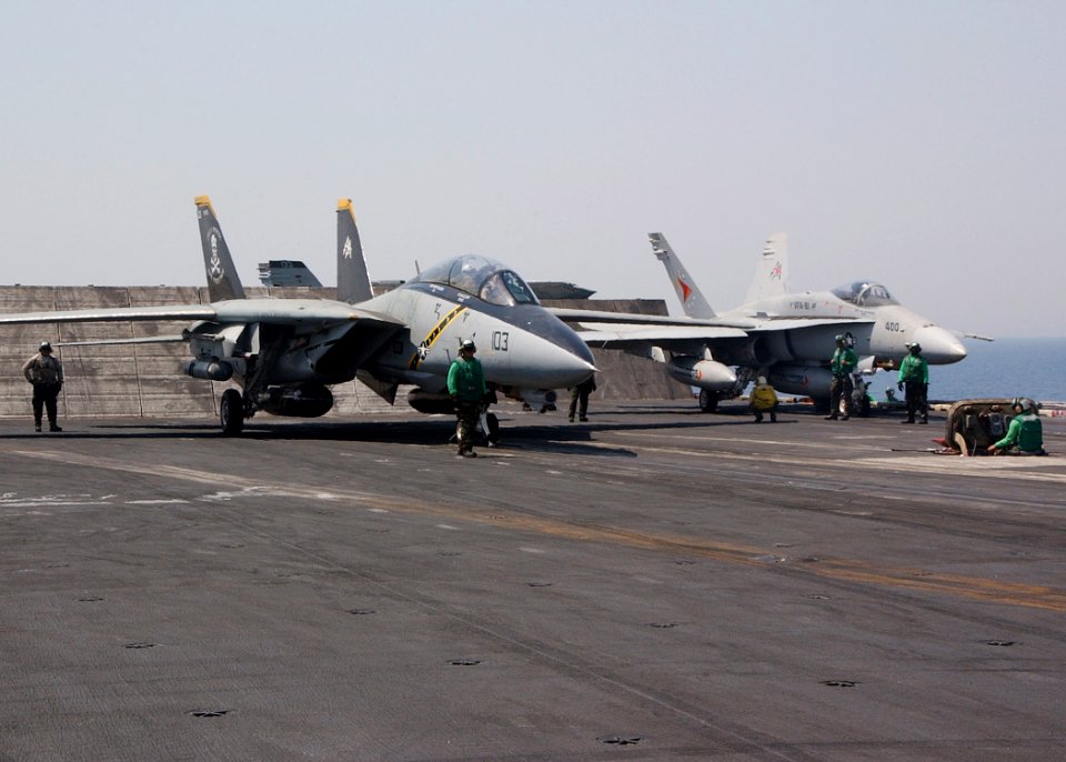 US Navy 040709-N-4374S-015 An F-14D Tomcat assigned to the Jolly Rogers of Fighter Squadron One Zero Three (VF-103) and an F-A-18C Hornet assigned to the Sunliners of Strike Fighter Squadron Eight One (VFA 81) makes final prepa