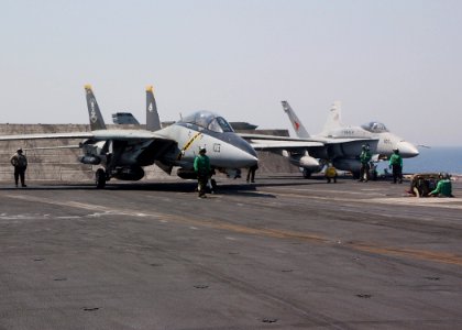 US Navy 040709-N-4374S-015 An F-14D Tomcat assigned to the Jolly Rogers of Fighter Squadron One Zero Three (VF-103) and an F-A-18C Hornet assigned to the Sunliners of Strike Fighter Squadron Eight One (VFA 81) makes final prepa