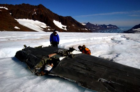 US Navy 040809-N-0331L-006 Lt. Cmdr. Christopher Blow, left, and Lt. Cmdr. Steve Dial examine the wreckage of a Navy P-2V Neptune aircraft that crashed over Greenland in 1962 photo